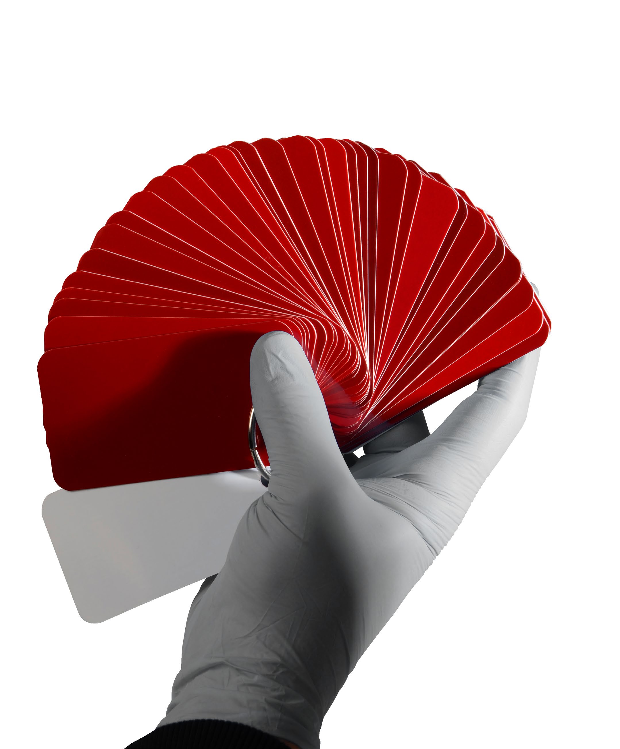 Gloved hand fanning out a red ARC colour swatch deck
